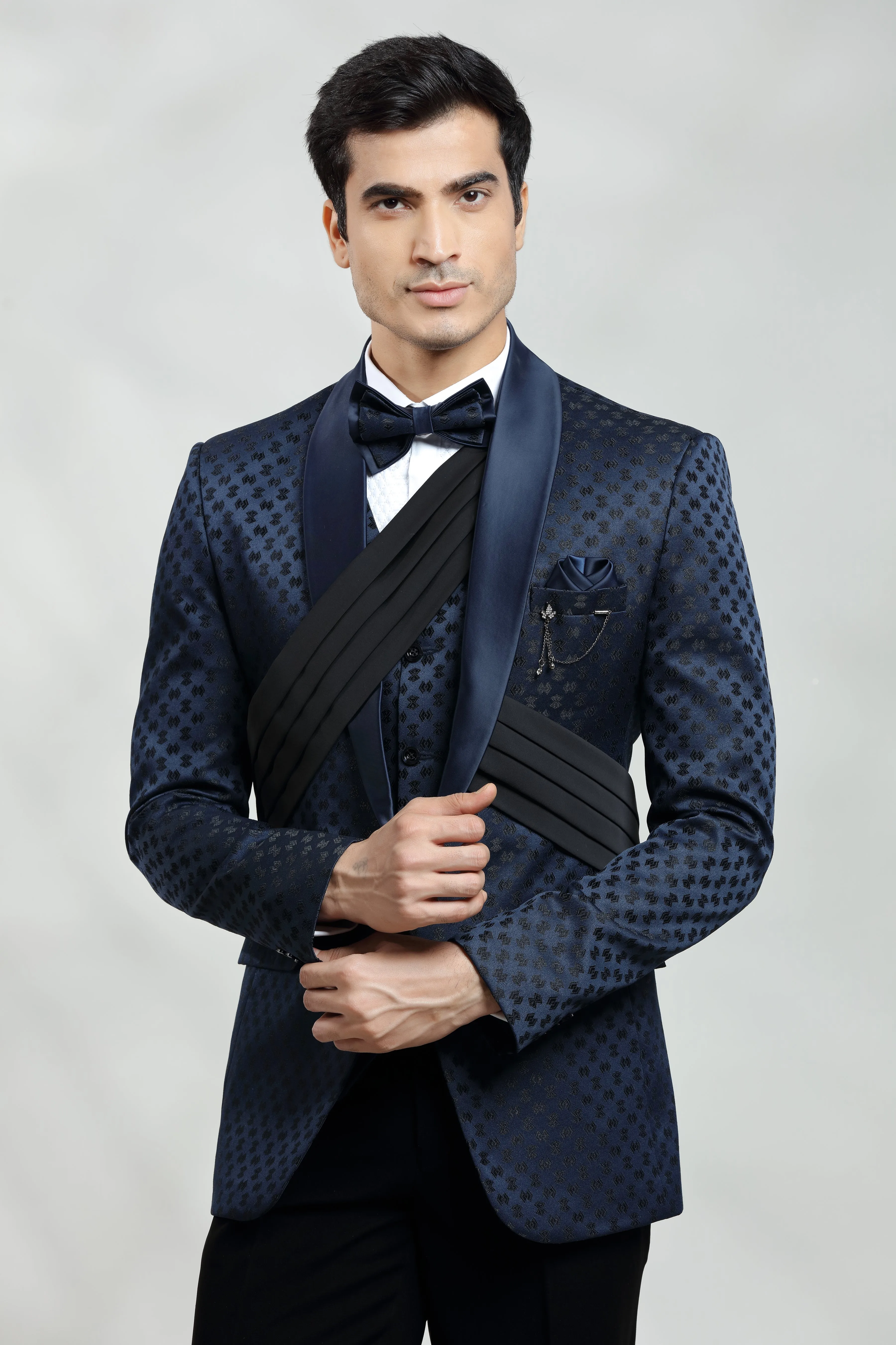 Dark blue self embroidered tuxedo with fabric pleat detail.